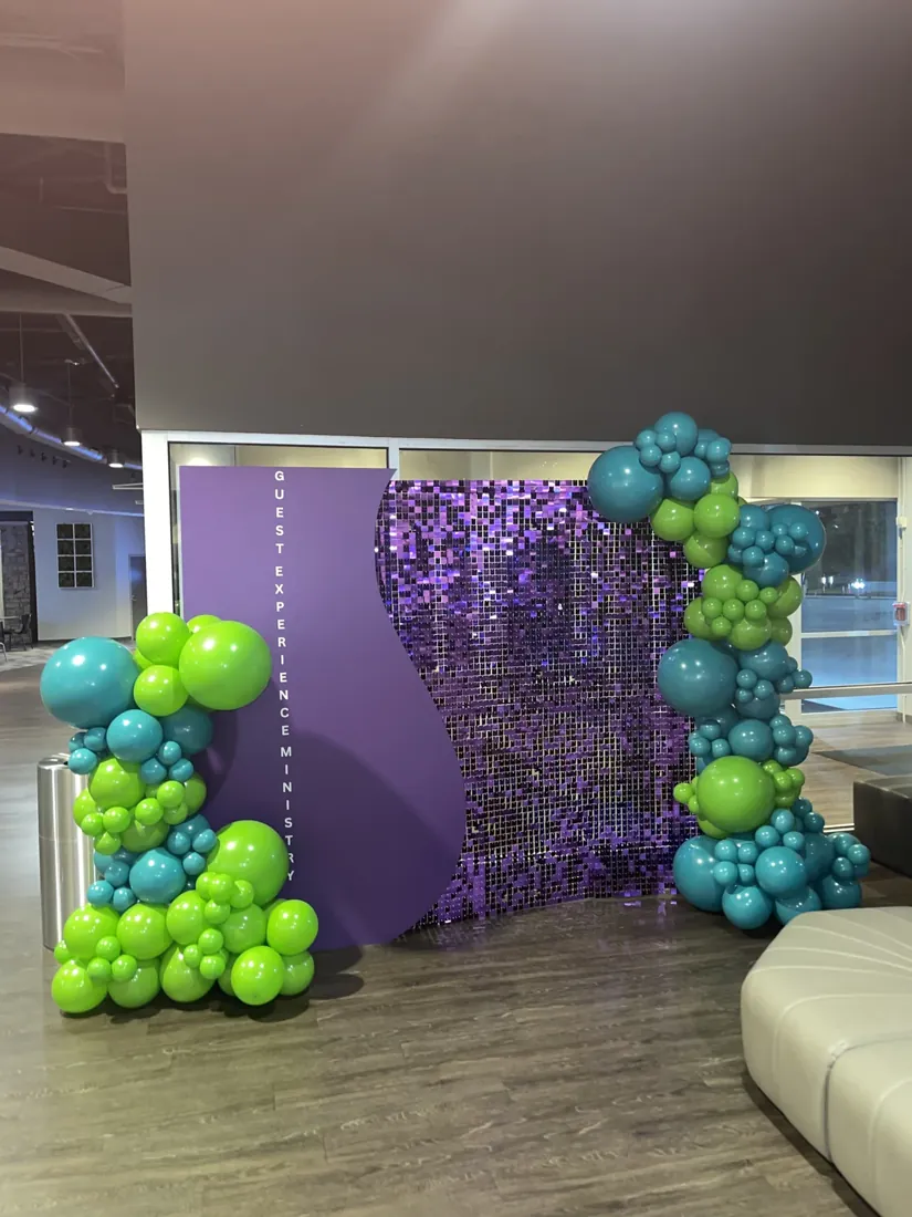 Turquoise and lime balloon clusters beside a purple sequin backdrop — detail view
